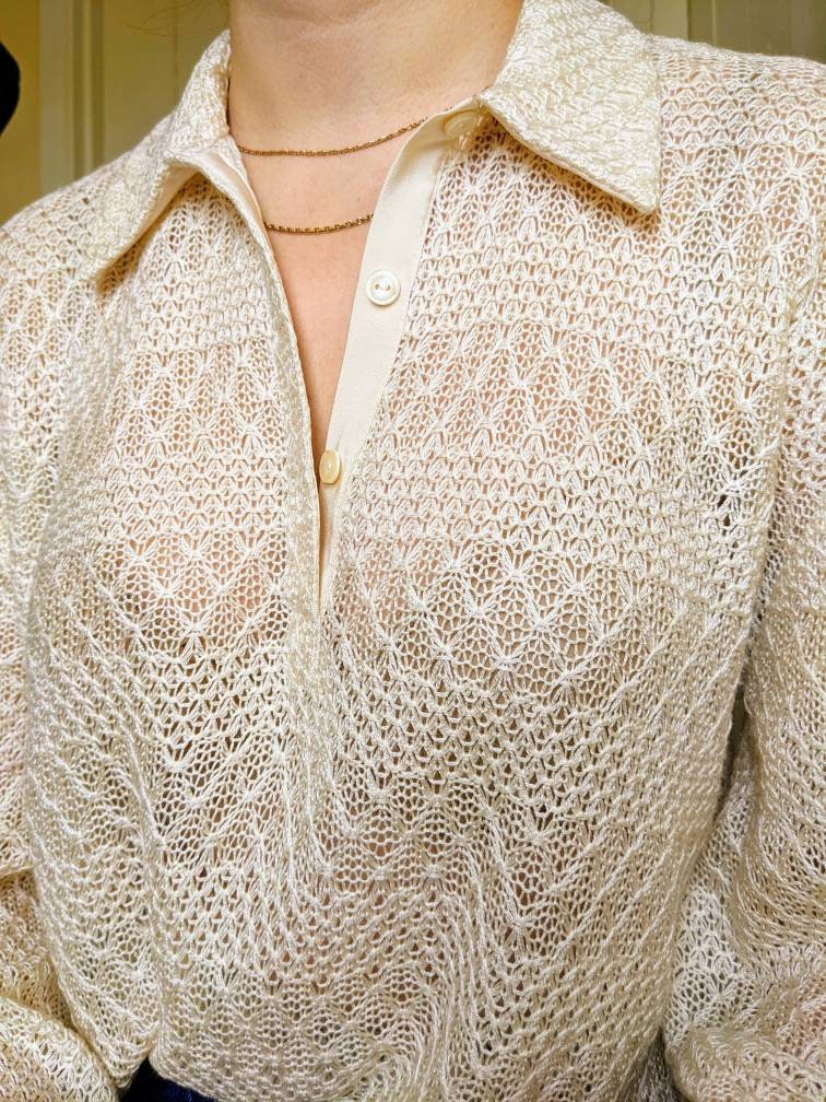This closeup shows the fabric in more detail. The lace pattern creates horizontal stripes alternating between loose weave chevrons and a tighter decorative knit. The top is a little sheer and you can just see the model's bra through the fabric.